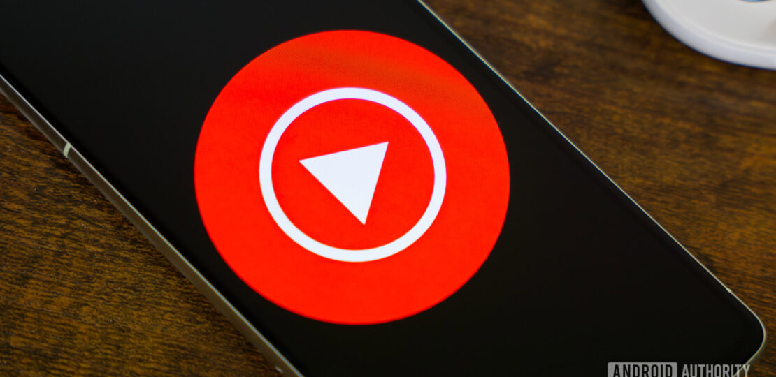 YouTube-Music-logo-on-smartphone-next-to-headphones-and-Nest-Mini-3.jpg